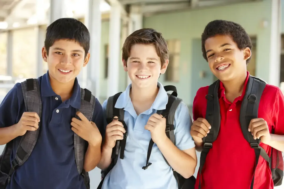 Three boys smiling at school
