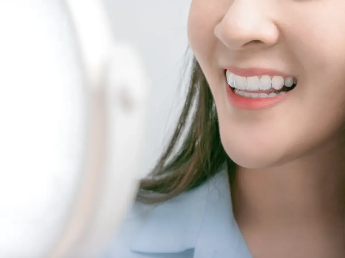 Woman with clear aligners smiling