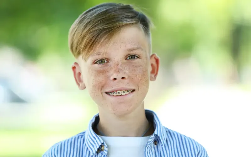 Smiling boy with braces outdoors
