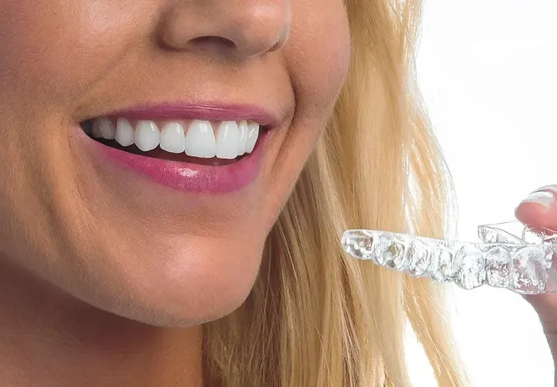 Smiling woman with Suresmile aligners